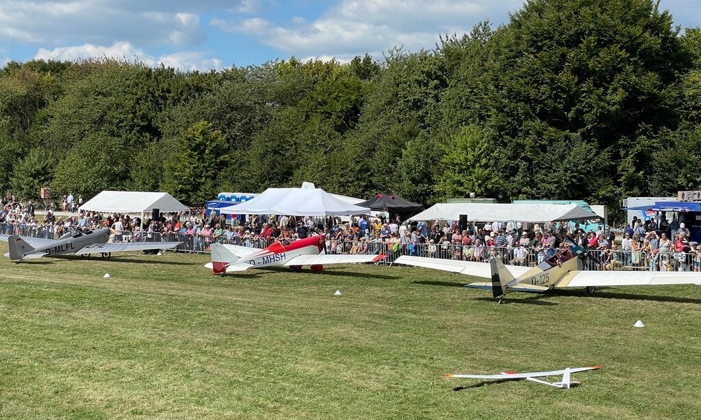 Segelflugzeuge auf der Wiese des Düsseldorfer Aero-Klubs beim Flugplatzfest, mit Publikum und Ständen