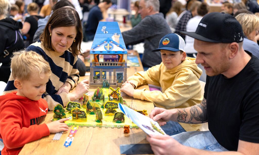 Familie spielt auf der Messe Spiel Essen ein Gesellschaftsspiel
