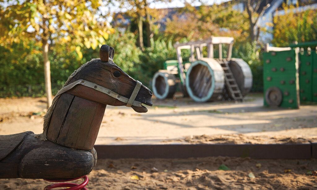 Spielplatz mit Holzpferdim Vordergrund