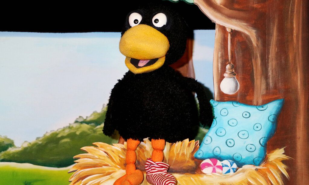 Szene aus dem Puppentheaterstück Rabe Socke, ein Rabe sitzt in seinem Nest
