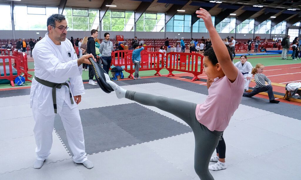 Ein Taekwondo-Lehrer übt mit einem Mädchen bei Kids in Action