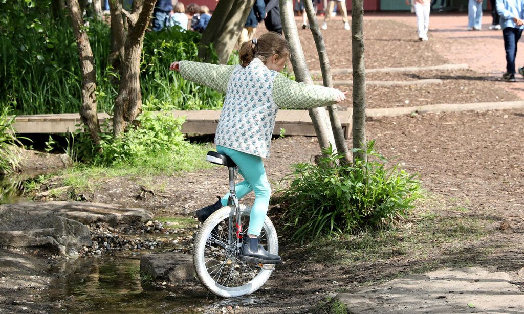 ein Mädchen fährt draußen Einrad