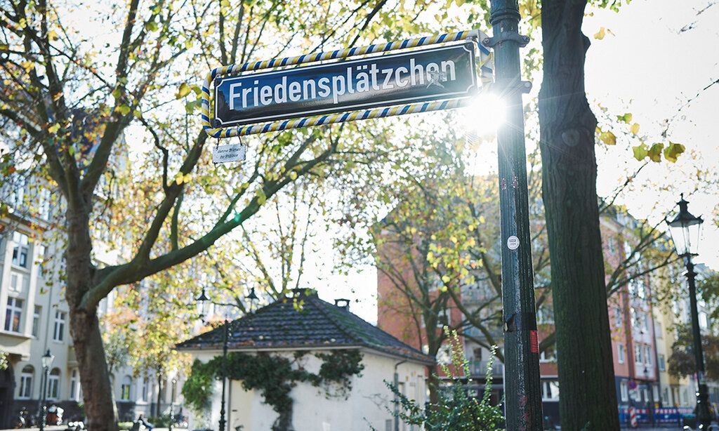 Straßenschild Friedensplätzchen im Gegenlicht