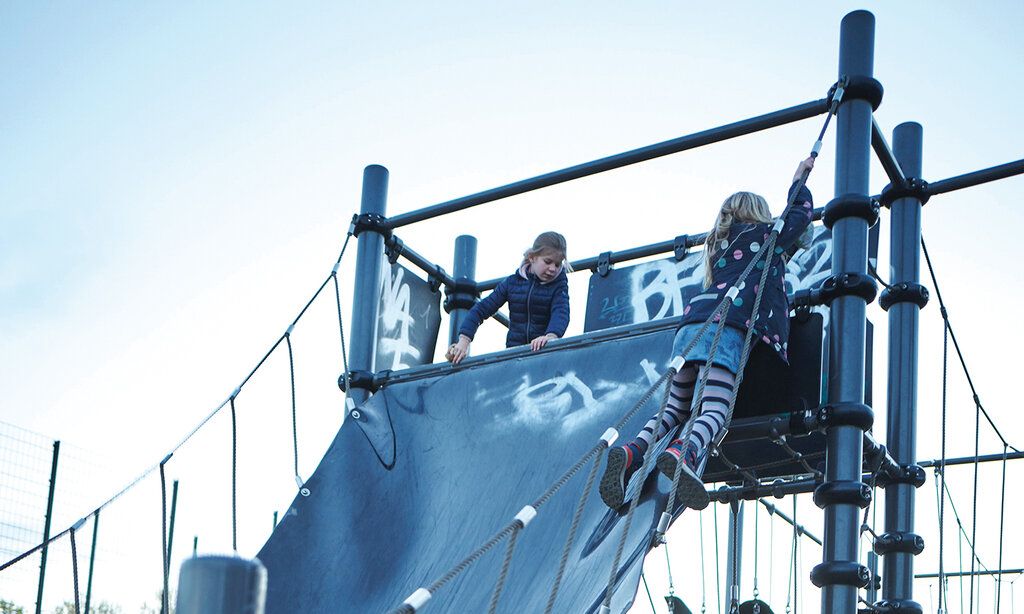 Zwei Mädchen spielen auf einem Klettergerüst