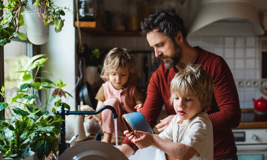Vater mit zwei Kindern in der Küche beim Abspülen