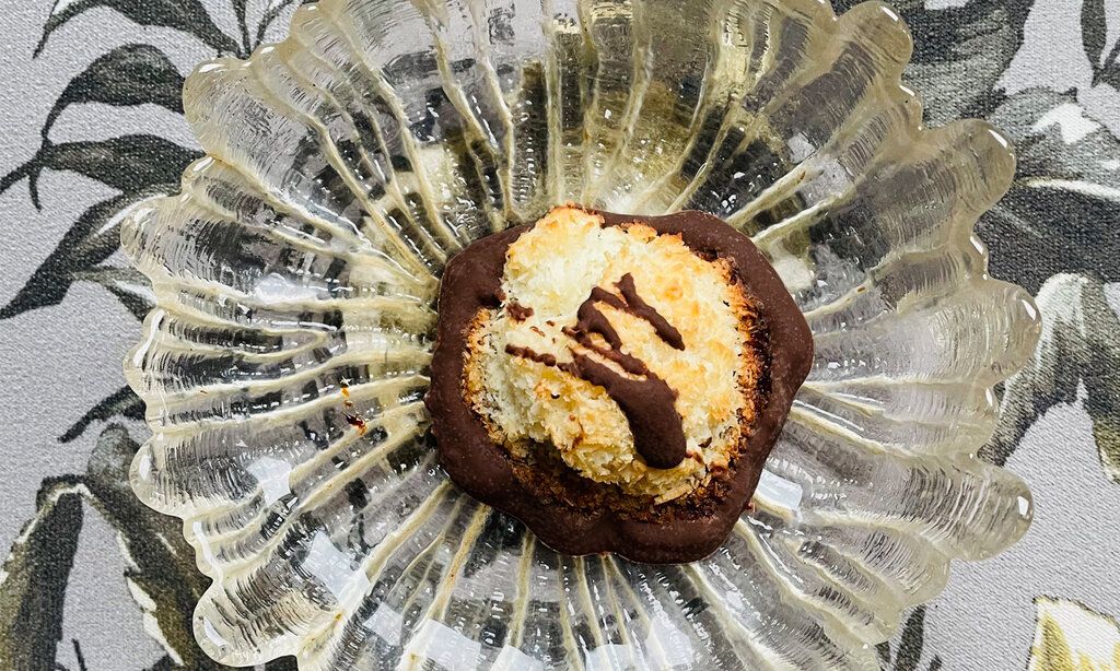 eine Kokosmakrone auf einem Glasschälchen, von oben fotografiert