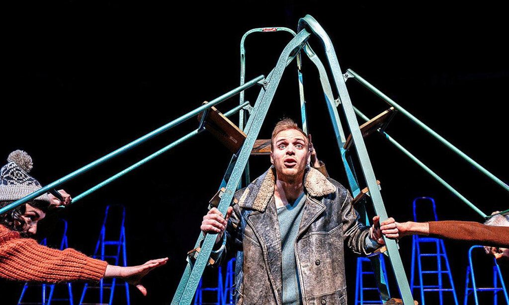 Schauspieler steht auf der Bühne, unter einer Leiter