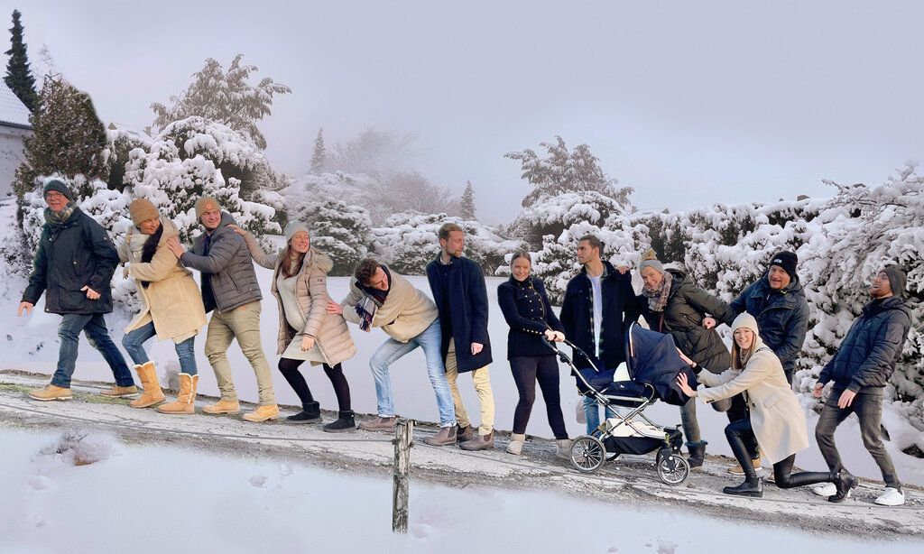 sehr viele Personen stehen hintereinander auf einer Straße, die nach oben führt, es liegt Schnee