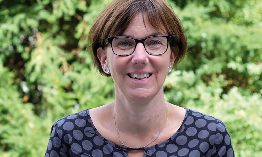 Porträt von der Pfarrerin Kirsten Düsterhöft, im Hintergrund grünes Gebüsch