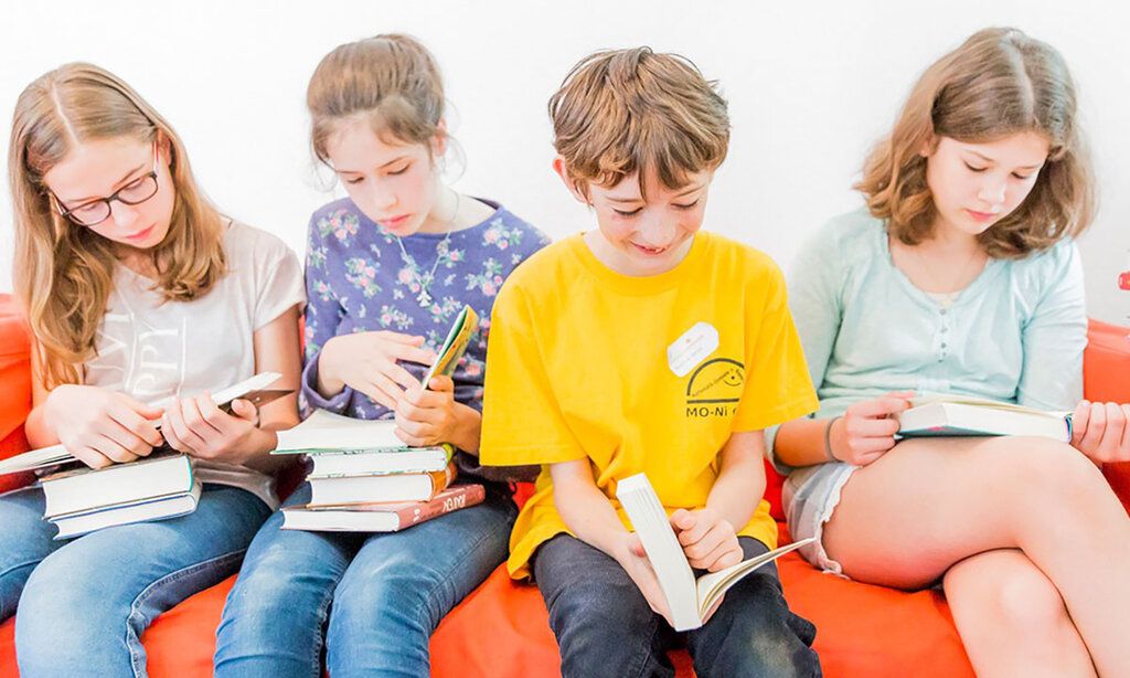 Lesende Kinder auf einer Couch