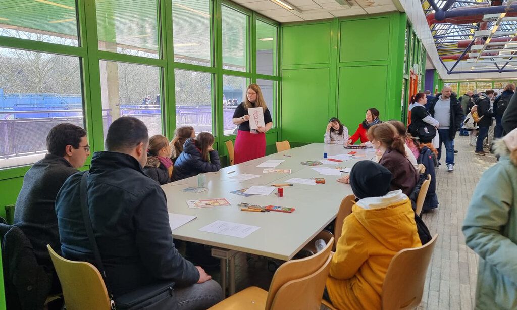 Jugenliche und Kinder sitzen zusammen an einem Tisch bei der COMIC UND MANGA-CON DÜSSELDORF