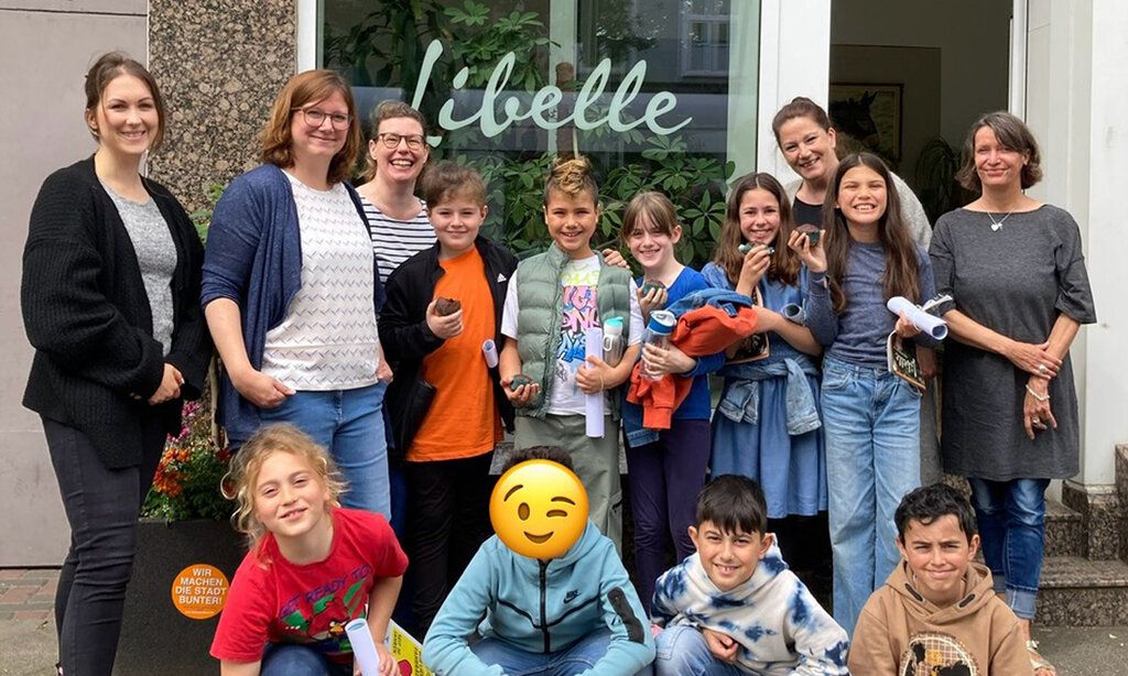 Gruppenbild: Schüler der Zeitungs AG der Lenne Schule mit Mitarbeiterinnen der Libelle, vor dem Ladenlokal der Redaktion