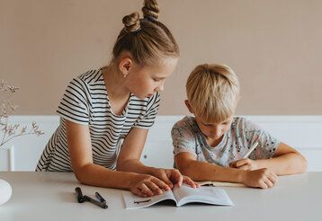 Mädchen und Junge machen Hausaufgaben