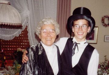 Andreas Ehrlich als Jugendlicher mit Zylinder, umarmt seine Oma