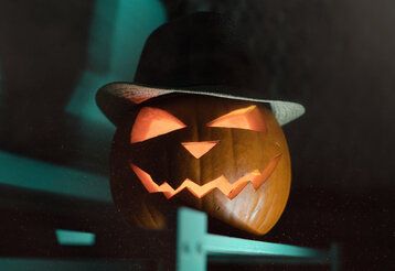 geschnitzter Halloween-Kürbis mit Hut im Dunklen