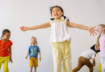 fünf Kinder bewegen sich mit Freude in einem Raum