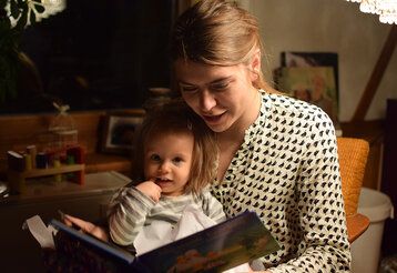 Mutter liest ihrer Tochter abends aus einem Buch vor