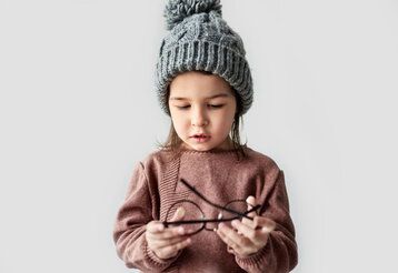 Kleinkind mit Brille in der Hand