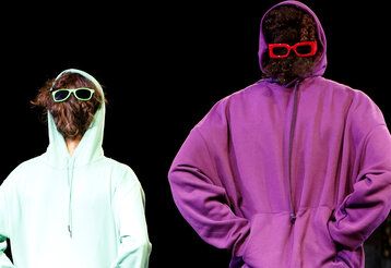 Zwei Personen haben einen Hoodie falsch herum an und haben sich Sonnenbrillen in die Haare am Hinterkopf gesteckt