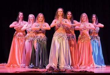 Eine Gruppe von Frauen zeigt einen orientalischen Bauchtanz auf einer Bühne.