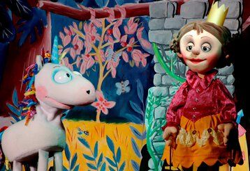 Das NEINhorn und die Prinzessin stehen sich auf der Puppenbühne gegennüber.