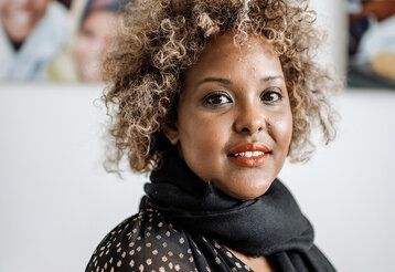 Jawahir Cumar in der Beratungsstelle vor Fotos