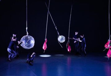 Jugendliche experimentieren auf einer Bühne mit verschiedenen schwingenden Objekten