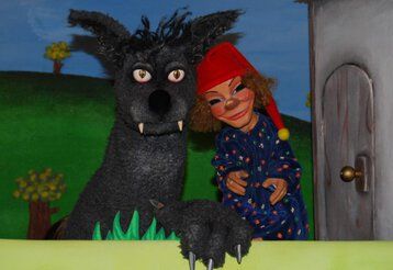 Die Puppen von Kasper und der Wolf vor der Puppenspielbühne