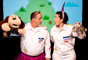 Schauspieler mit Einhorauf dem Kopf spielen mit Handpuppentieren das Stück "Das Neinhorn".