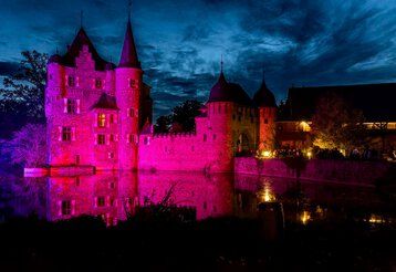 Burg Satzvey am Abend mit gruseliger Halloween Beleuchtung.