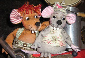 Zwei Mäuse-Handpuppen sitzen neben einer Milchkanne