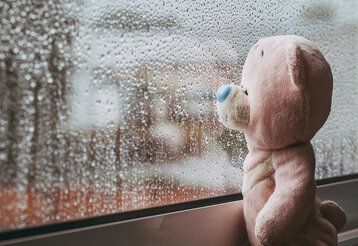Trauriger Teddybär am Fenster Regen
