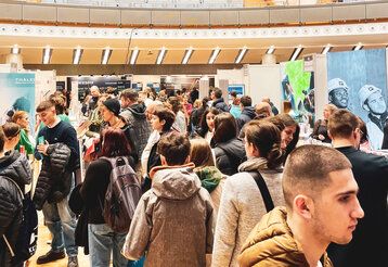 Viele Jugendliche bewegen sich durch eine Ausstellungshalle.
