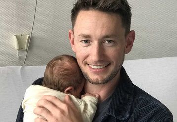 Vater Oliver hält Baby Carlotta im Arm