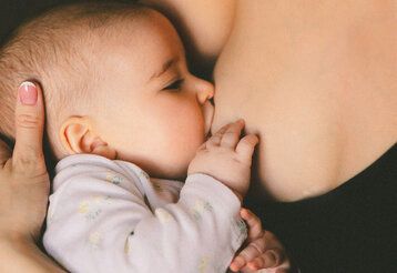 Baby trinkt an der Mutterbrust