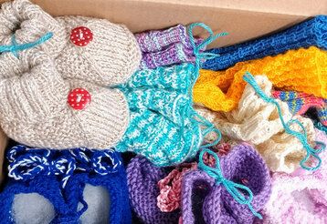 selbstgestrickte Babysöckchen vom Strickcafe in einem Karton