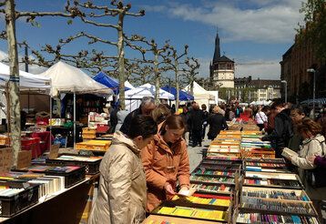 Büchermeile auf der Rheinpromenade, Besucher:innen stöbern in Bücherkisten