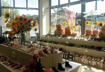 Innenraum des Geschäfts Calino, viele Kinderschuhe, Blick nach draußen auf den Belsen Platz