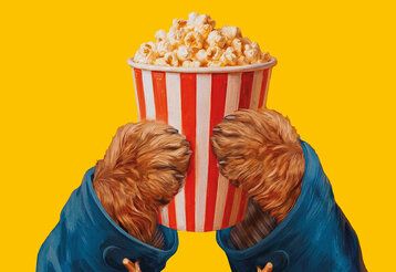 Hände von Paddinton Bär halten einen Becher mit Popcorn ins Bild, Hintergrund: gelb