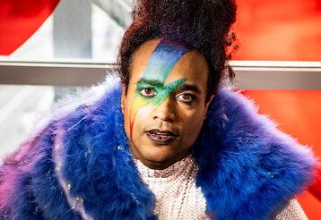 Schauspieler vor roter Wand, Regenbogen-Blitz im Gesicht geschminkt   Auf dem Bild Jonathan Gyles   Foto: Thomas Rabsch