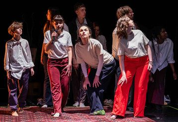 Schauspieler:innen laufen auf der Bühne herum als würden sie etwas suchen