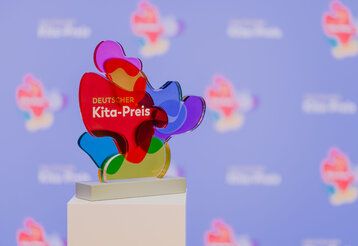 Trophäe des Deutschen Kita Preises aus einem weißen Sockel