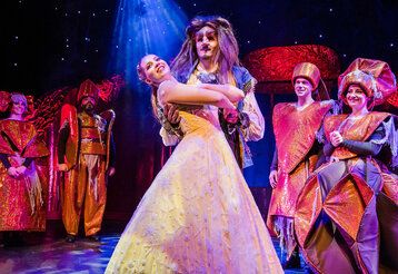 Schauspieler auf der Bühne, die Schöne und das Biest tanzen gemeinsam