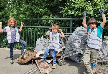 drei Kinder beim Müllsammeln am Dreck weg Tag