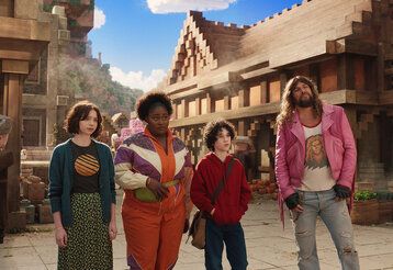 Szene aus dem Film Ein Minecraft Film, zwei Frauen, ein Junge und ein Mann stehen in einer Minecraft-Stadt