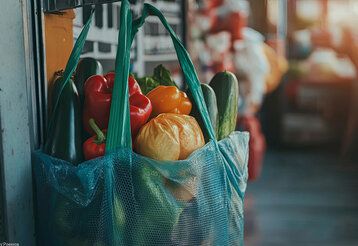 Eine wiederverwendbare Einkaufstasche, gefüllt mit frischem Obst und Gemüse, um Plastikmüll zu vermeiden