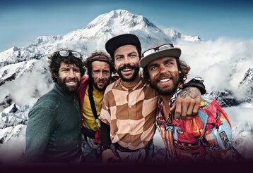 Vier Bergsteiger vor Bergpanorama