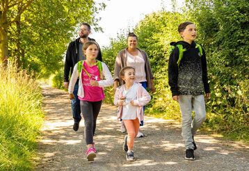 Vater, Mutter und drei Kinder wandern im Neandertal