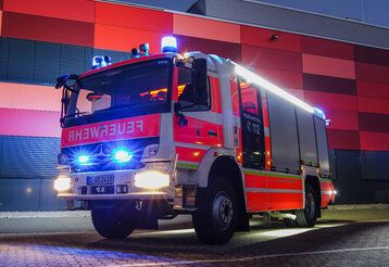 ein Feuerwehrwagen steht abends vor dem Gebäude der Freiwilligen Feuerwehr Düsseldorf-Garath