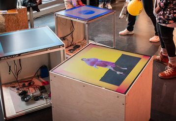 Verschiedene große Würfel mit Bildern, daneben Kinderbeine